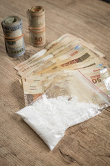 Money and drugs on a wooden table