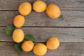 Letter C made from apricots on a wooden background. Vitamin C concept.