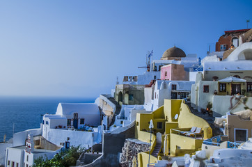 At dusk the sun bathes the traditional and colorful Greek houses in the town of Oia
