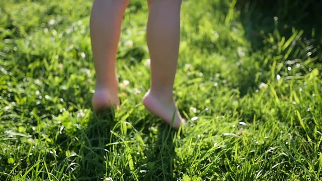 children's bare feet running through the grass. Fun outdoors