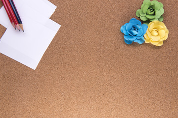 Pencils and paper with paper roses on a wooden background with copy space 