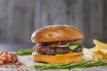 Burger with potatoes on cutting Board, telephoto