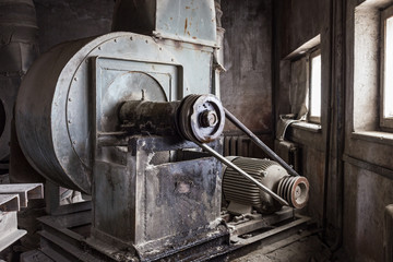 Old mechanisms covered with a thick layer of dust in an abandoned factory