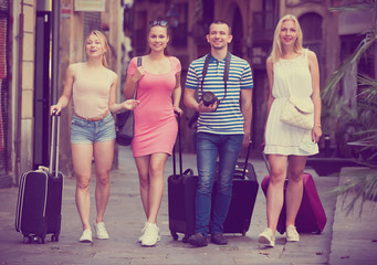 Fototapeta premium four travellers walking with suitcases