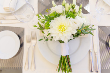 Wedding bouquet lies on the plate.