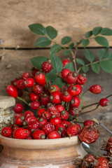 Medicinal plants and herbs composition: Berries of a viburnum, Dog rose hips; Flower petals of calendula, tansy and daisy. herbal Tea with, essential oil room for text  
