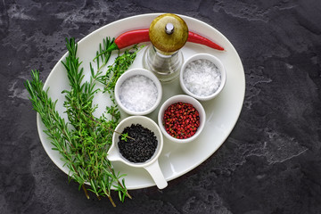 salt, pepper and herbs on a white plate