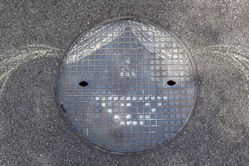 Smiling chalk drawn girl head on manhole cover, background