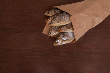 Dried fish on the table. Salty dry river fish on a dark wooden background. top view with copy space