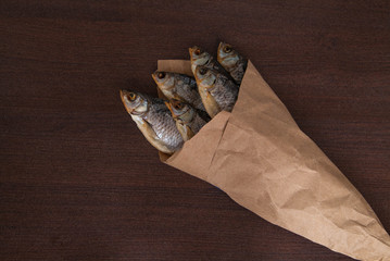 Dried fish on the table. Salty dry river fish on a dark wooden background. top view with copy space