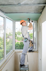 Worker is fixing the drywall.