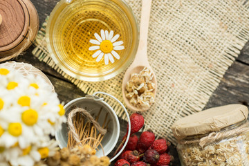 Obraz na płótnie Canvas cup of herbal chamomile tea with fresh daisy flowers on wooden wooden background. doctor treatment and prevention of immune concept, medicine - folk, alternative, complementary, traditional medicine