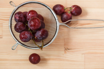 bunch of red grapes on a wooden table. Top view.