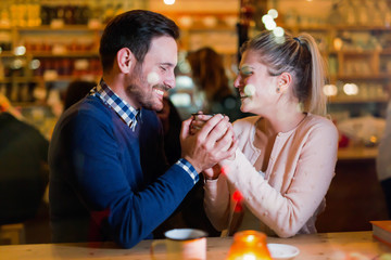 Happy couple talking at bar and having date