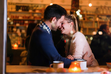 Happy couple kissing at bar and having date
