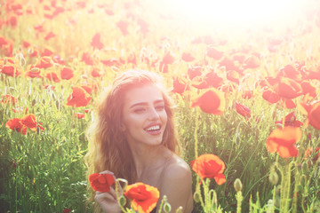 Obraz na płótnie Canvas beautiful woman on poppy field with long hair