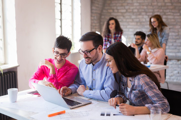 Coworkers working on project together in office