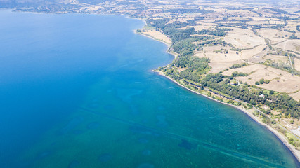 Vista aerea del lago di Bracciano dal comune di Anguillara Sabazia durante una bella giornata di sole. In acqua non ci sono barche