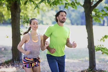 Young couple running in the park on a sunny day