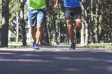 Two young men running in the park.