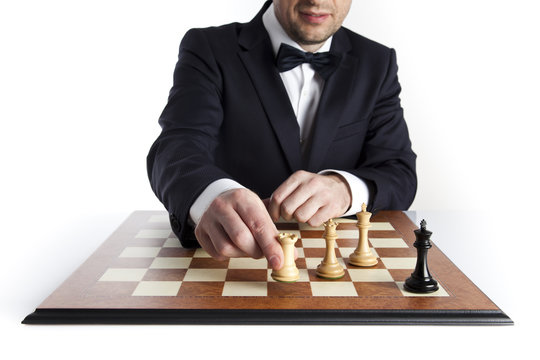 Game over. Smart man in a dark suit playing whites has just won a game of 
chess 