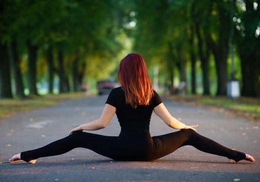 Dancing girl in a black body in the summer garden