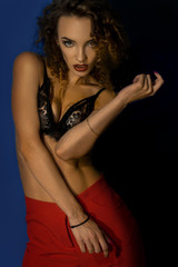 Gorgeous lady with curly hair and red pants posing on camera