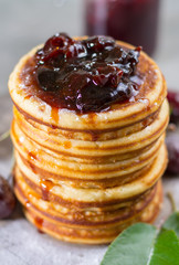 Homemade American pancakes served with cherry jam and fresh cherry on a wooden background