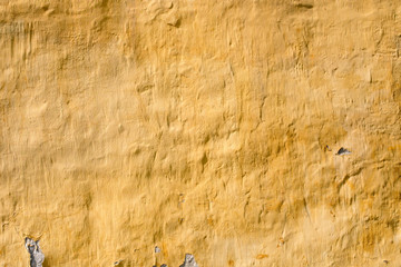 Old brick wall with old yellow plaster. Classic fasade