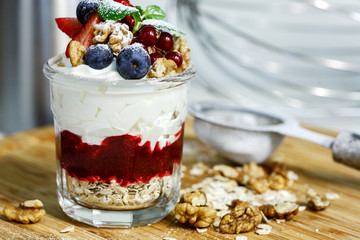 berry cream dessert in a jar with oat flakes and nuts