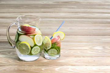 Detox water with cucumber and lemon  in pitcher and glass