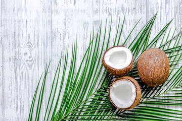 Fototapeta na wymiar Appetizing cocount and palm branch on wooden table background top view copyspace