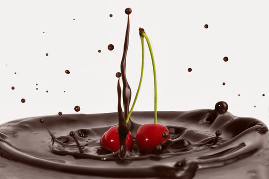 Two red cherries. A splash of chocolate from the fall of cherries. Delicious dessert