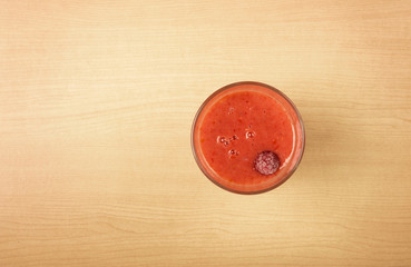 Raspberry blended drink on wood table, Flat top view
