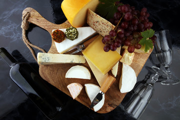 Fototapeta premium Cheese platter with different cheese and grapes