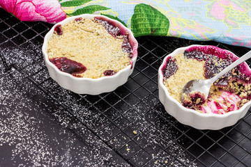 Homemade mix berry crumble in white ramekin. Healthy breakfast concept. Selective focus