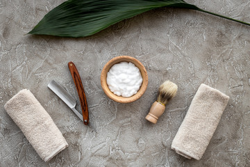 Fototapeta na wymiar Preparing for men shaving. Shaving brush, razor, foam on grey stone table background top view
