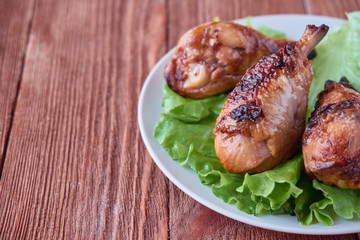 Grilled chicken legs with vegetables on a wooden background