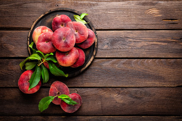 Peach, saturn or donut peaches with leaves