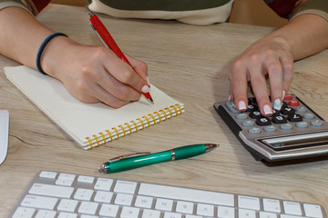 Savings, finances, economy and home concept - Female with calculator, Female holding pens, papers, notes