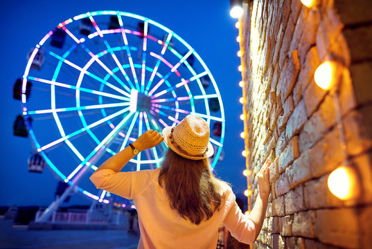 Woman Near Ferris Wheel At Night