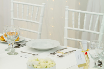 white chairs and fancy table set for a wedding dinner