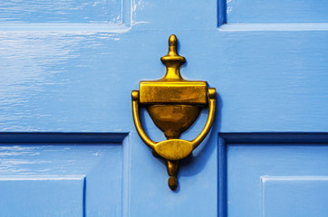 Door with brass knocker in the shape of a hand, beautiful entrance to the house