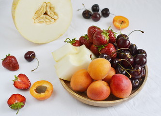 Healthy Fresh Breakfast Yogurt with Granola Fruits Berries Strawberries Apricot Melon Cherry Chamomile Close up White Background