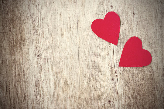 Two red hearts on a  wooden background. Copy space.