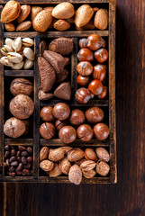 Nuts Mixed in a Wooden Vintage Box.Assortment, Walnuts,Pecan,Peanuts,Almonds,Hazelnuts,Macadamia,Cashews,Pistachios.Concept of Healthy Eating.Vegetarian.selective focus.