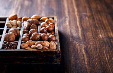 Nuts Mixed in a Wooden Vintage Box.Assortment, Walnuts,Pecan,Peanuts,Almonds,Hazelnuts,Macadamia,Cashews,Pistachios.Concept of Healthy Eating.Vegetarian.Copy space.selective focus.