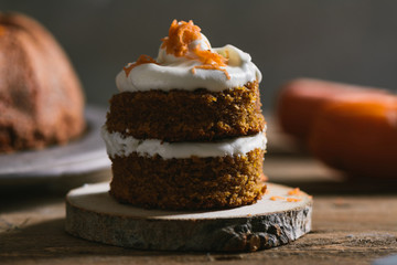 Mini carrot cake, stuffed with cream cheese, on rustic wood plate