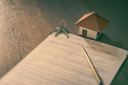 House keys on the rental agreement or the buy home contracts with the real estate property background.