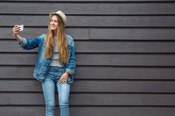 teen woman smartphone get selfie outside wood wall